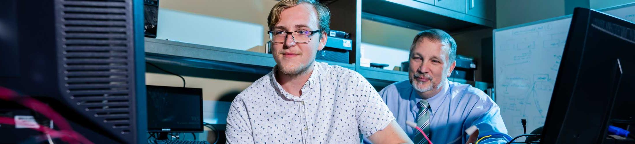 Professor working with student in computer lab.