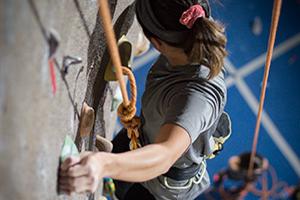 Student climbing on rock wall.