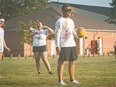 Students playing dodgeball outside on campus.